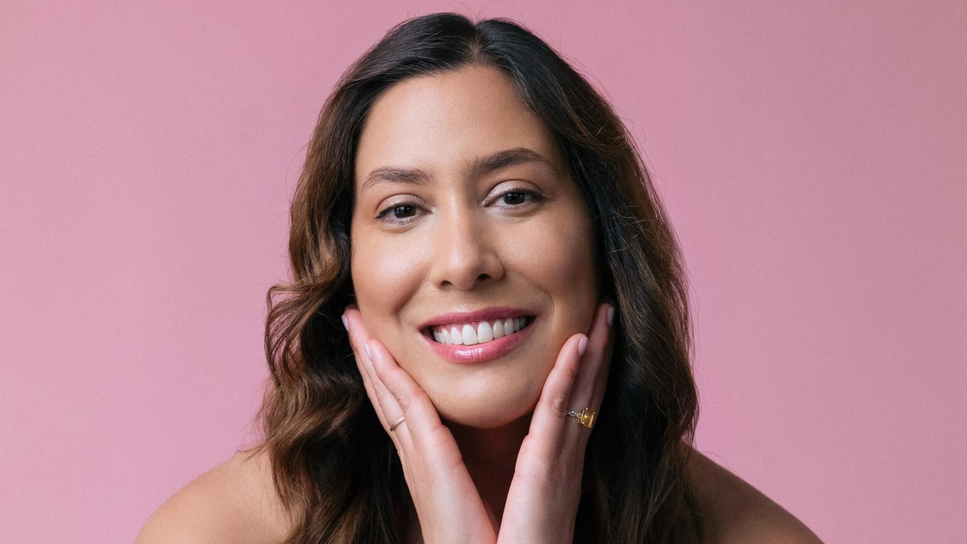 woman with hands on her face smiling
