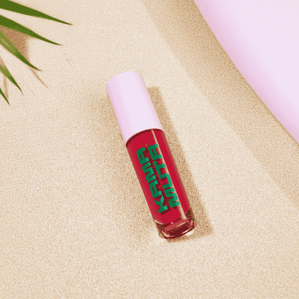 Red Kama Muta lip gloss with green text on a pink background