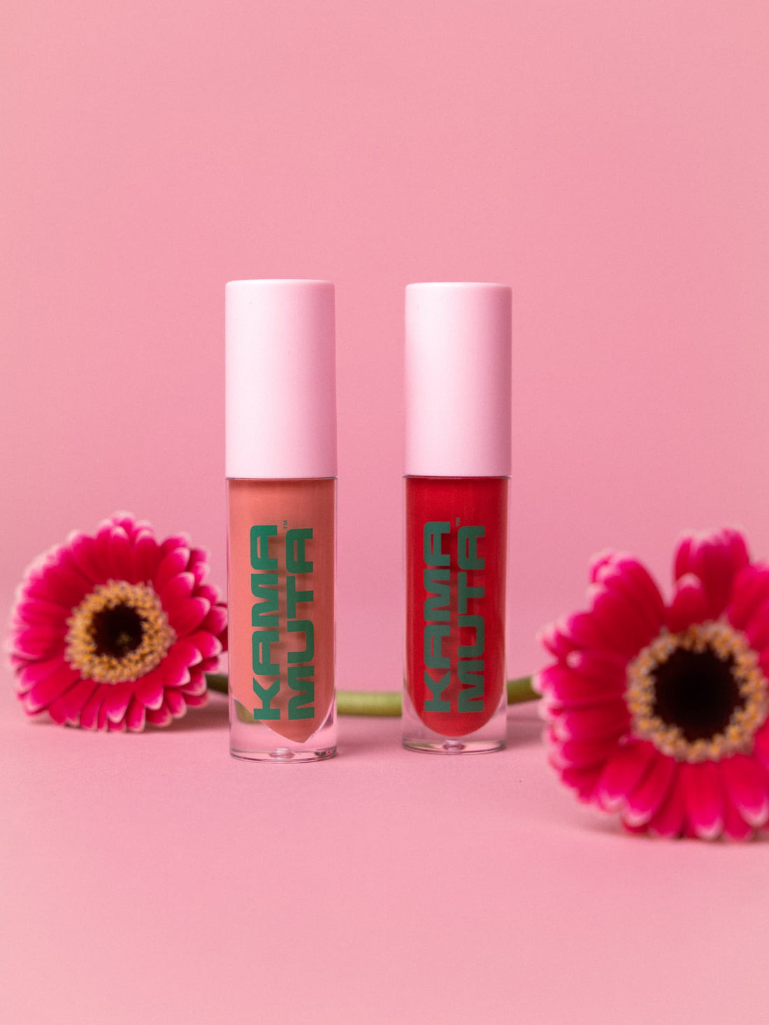 2 lip glosses next to flowers