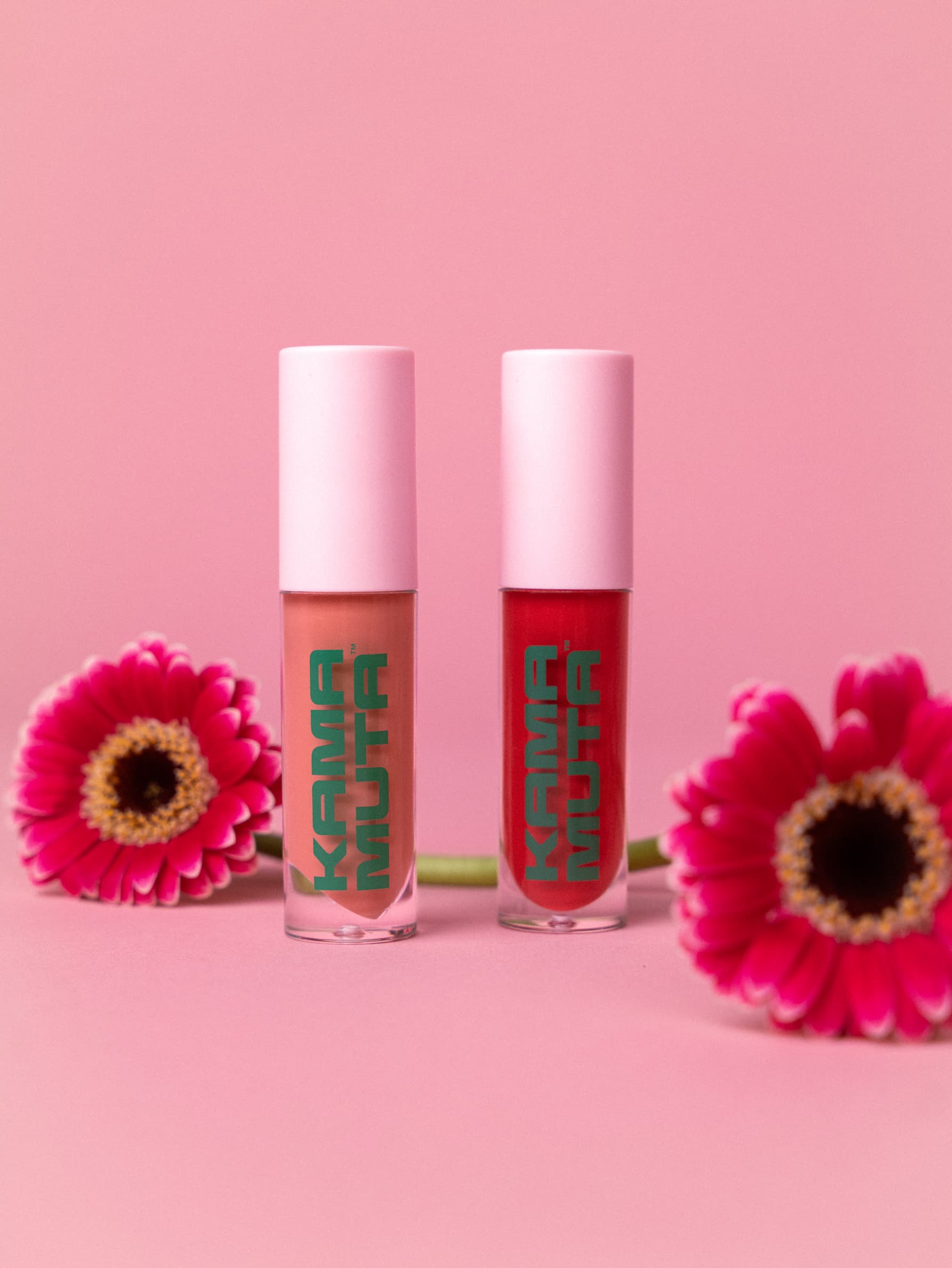 2 lip glosses next to flowers