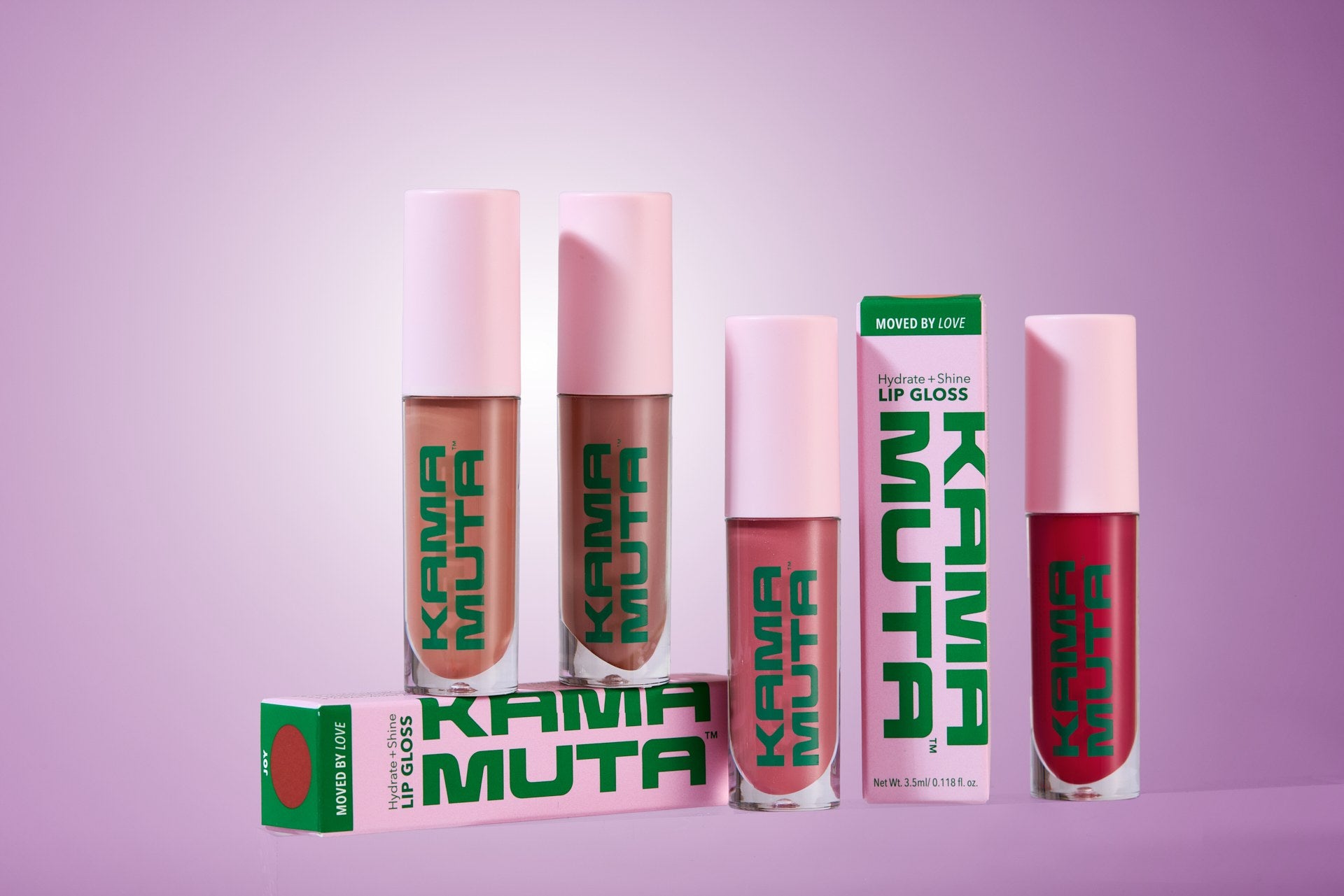 Kama Muta lip gloss bottles and packaging on a purple background